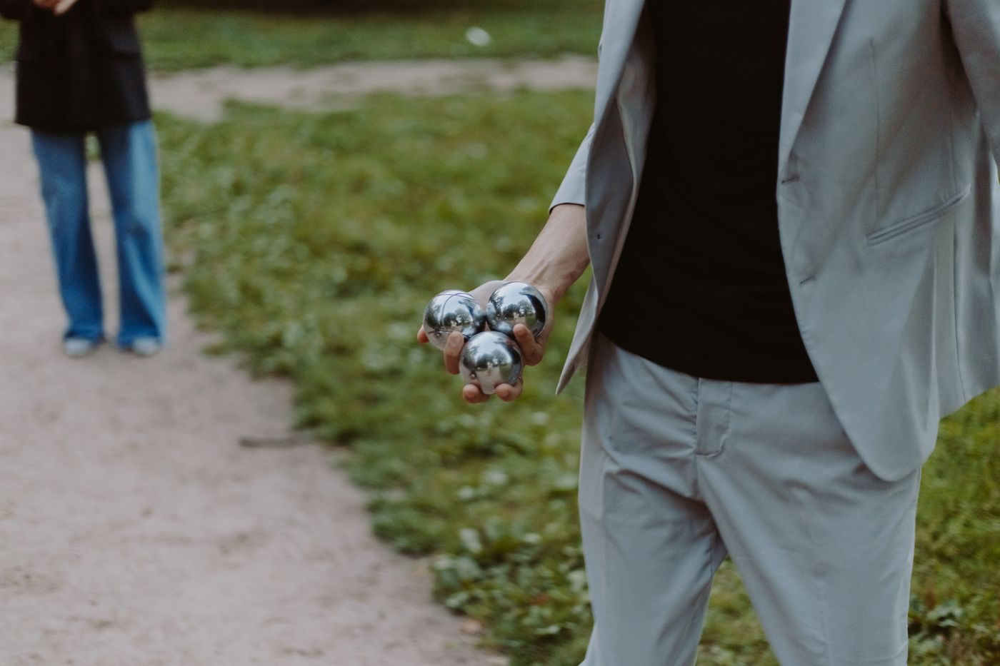 Joueur tenant un triplet de trois boules de pétanque dans la main