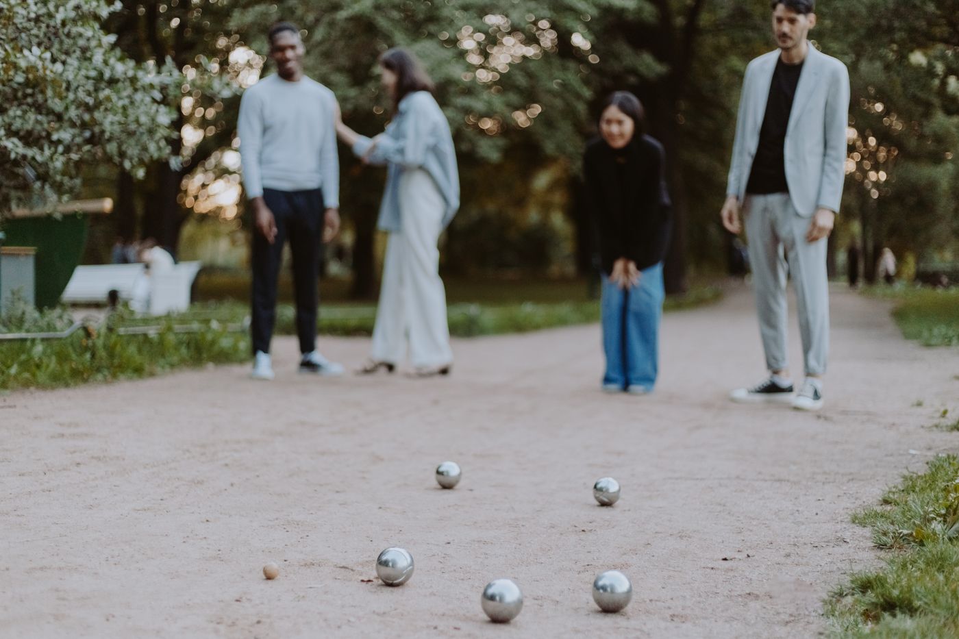 Partie de pétanque sur une piste en gravier, boules en acier au premier plan